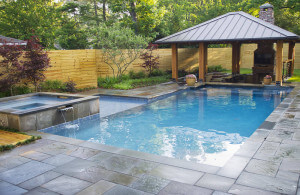 A sleek traditional pool with spa and scupper.